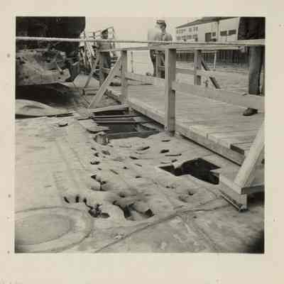 A small walkway makes passage possible for tourists viewing the damaged deck on the starboard side of the USS Laffey.