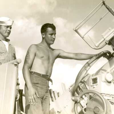 2019.06.48-2: Two men standing outside near one of the 40 mm anti-aircraft guns.