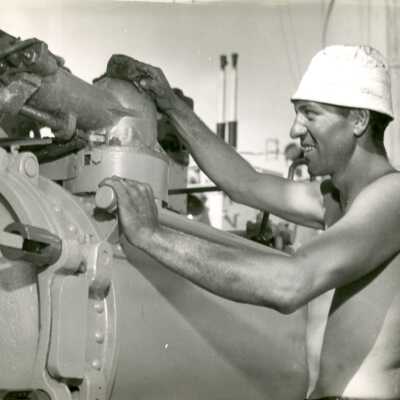 2019.06.48-6: Sailor manning a torpedo launcher on deck.