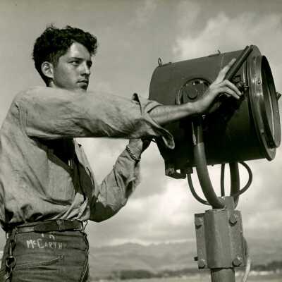 2019.06.48-7: Thomas McCarthy stands on deck and operates a signal light.