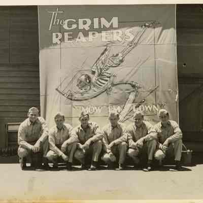 Several Members of Fighting Squadron Ten (VF-10) Sitting in Front of a Grim Reapers Banner