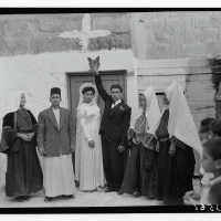 Bethlehem bride and groom touch leaf and yeast above the doorway to their prospective home.