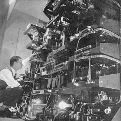 Hal Bubb (callsign unknown), W1AW chief op, behind the four transmitters he built for the W1AW Maxim Memorial Station prior to installation. Probably May 1938.: Image from the cover of QST, Jul 1938, description on p. 8.