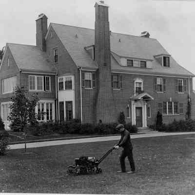 Gardener Enoch Dunn mowing the lawn at 6 East Laurel Avenue