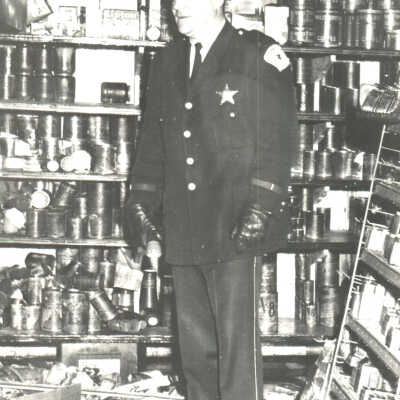 Police officer in front of storeroom shelves