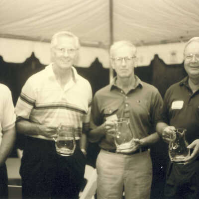 Four Men Holding Glass Pitcher