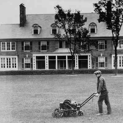 Gardener Enoch Dunn mowing the lawn at 6 East Laurel Avenue