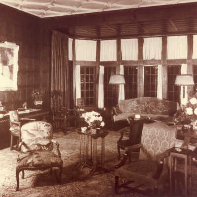 Room in White Oaks with tall windows and portrait on panelled walls