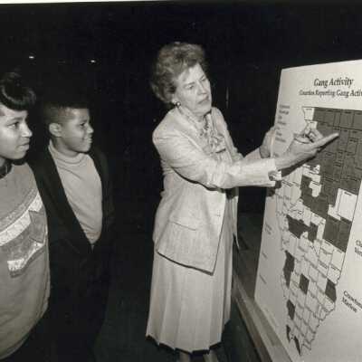 Virginia Fiester Frederick pointing at a map that shows gang activity