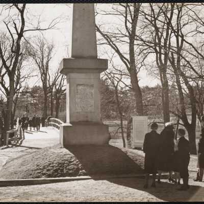 Obelisk which marks sport where first British soldier fell - in background is "Rude bridge" + Concord Minute Man.