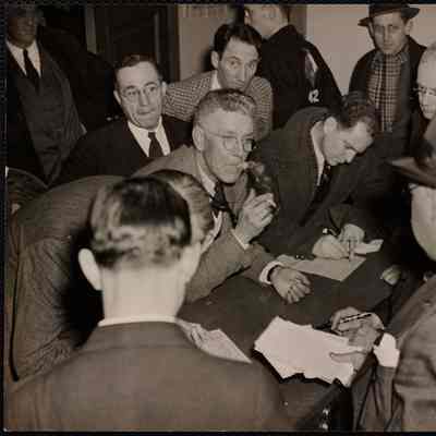 Judges + timers signing record blanks - Hillman is smoking cigarette.