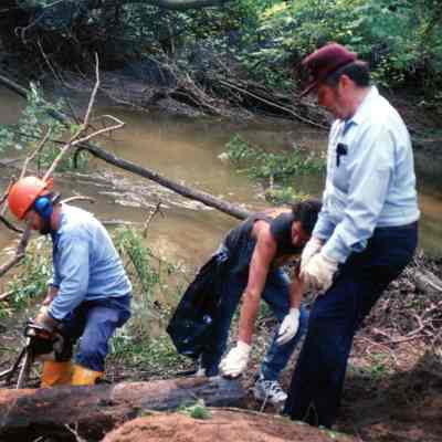 Gordie using chainsaw while Ken watches