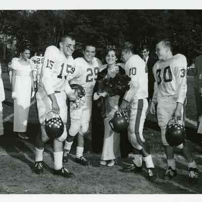 Football players with Homecoming Queen