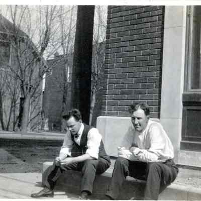 Former Cullen building in background. Men sitting on steps of Detroit Edison Building, SE corner Michigan and Biddle. Larry Parre, Claude Arthur