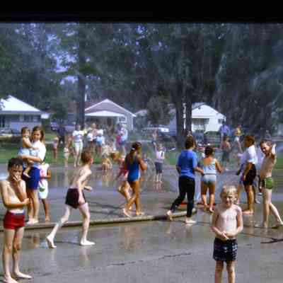 Kids playing in sprinklers during 1969 centennial