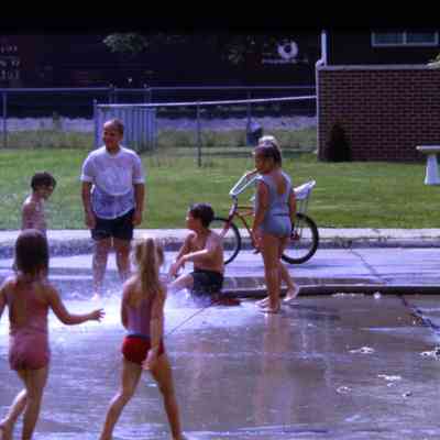 Kids playing in sprinklers during 1969 centennial