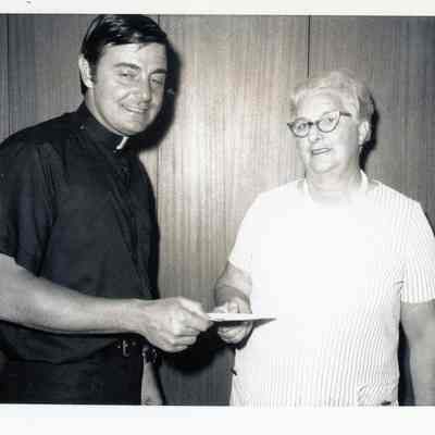 Fr. Sayers presenting savings bond to Catherine Spaulding