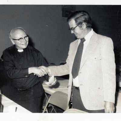 Father Haney receiving $20,000 check from festival proceeds from John Rowland