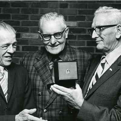 Harold Dietrich presents watch to Floyd Miles Dietrich and on the very left is a Hersahl Winn Employee.