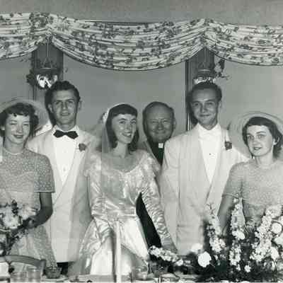 Bernice and Murray Millar on Wedding Day on 07/16/1949 with Father Haney in background.