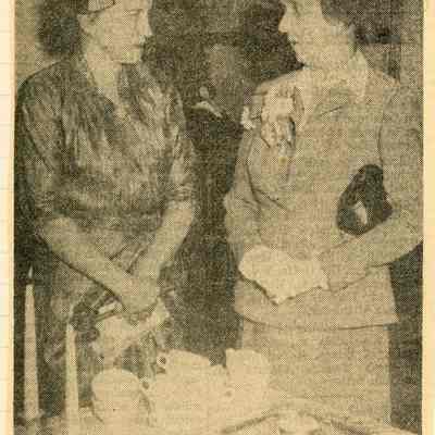 Mrs. Harris Wilson, president of the Arche Club, talks with Miss Clara Hosie, of Detroit, charter member of the club, at the 50th anniversary tea and antique show last Friday in the Congregational Church.