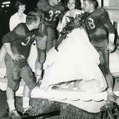 Football players with Homecoming Queen