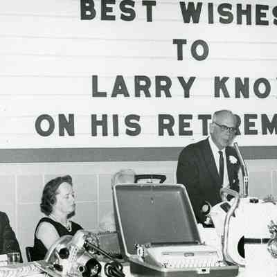From left: Wallace Arrowsmith, Mrs. E.A Britton, Rev Britton ( behide typewriter case), Larry Knox (speaking) and Mrs. Knox.