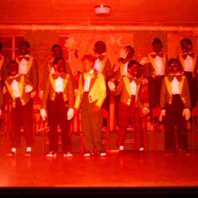 This image depicts blackface, a racist characture of African Americans. This photo was taken in another place and time, but is important for the historical record and to show that racist charactures happened here and everywhere.