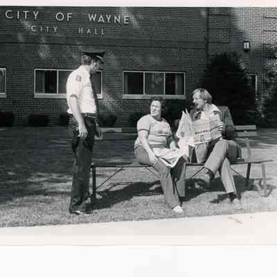 Officer talking to residents in front of City Hall