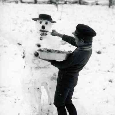 Boy building a snowman.