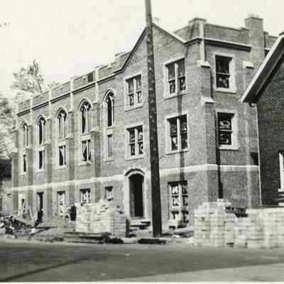 church house under construction and parsonage on right