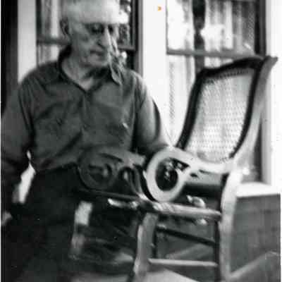 A man looking at a rocking chair.