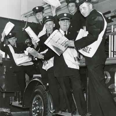 Firefighters selling newspapers for Goodfellows