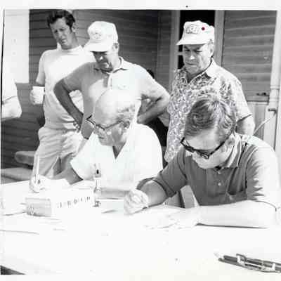 A Group of Men Signing Papers