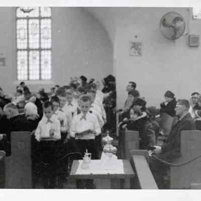 Fr. Haney serving communion to boys choir 1967
