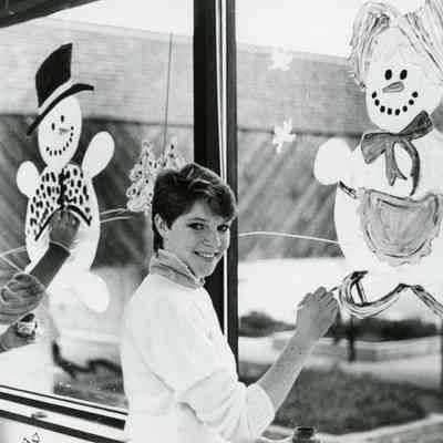 Unknown students painting christmas decorations on windows