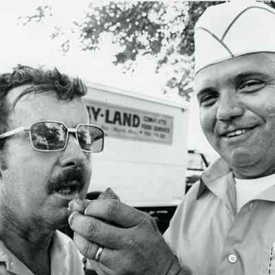 Dave Young feeding BBQ Chicken to a customer.