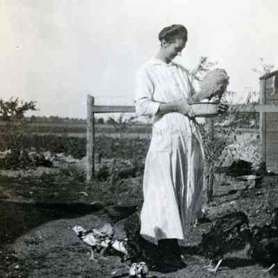 Women feeding chickens.