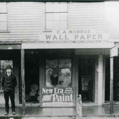Charles "Charley" Monroe in front of his shop in the Cheney Block