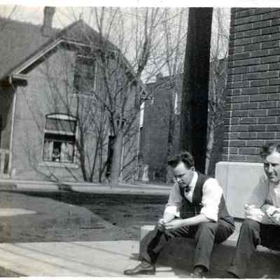 Former Cullen building in background. Men sitting on steps of Detroit Edison Building, SE corner Michigan and Biddle. Larry Parre, Claude Arthur