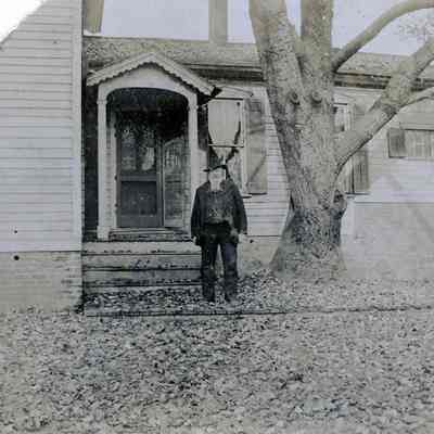 William Pettingill under the poplar tree outside his home on Biddle St, facing out to Brush St.