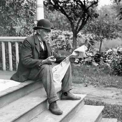 Otis Warner reading a newspaper.