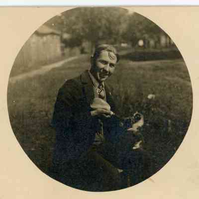 Clarence Millman with James Houston's Blacksmith Shop in the background.