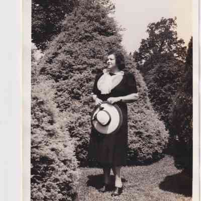 Photo - Woman in black dress standing among trees