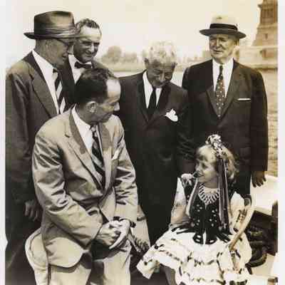 Arthur W. Page and business associates and young girl with Statue of Liberty Island in background