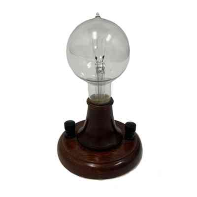 Edison light bulb commemorating the 50th Anniversary of Edison's 1879 light bulb, on wood base