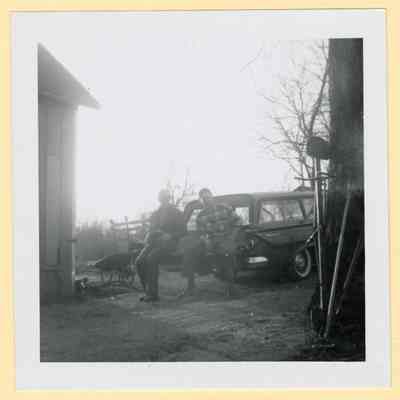 Two men on car, backyard of BG Home, C. 1960s