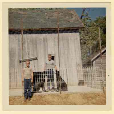 Frank and Brian Eul by barn, C. 1960s