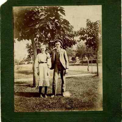 Man and woman standing in front of trees