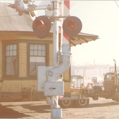 Broomfield Depot on Flatbed Truck Passing Railroad Signal